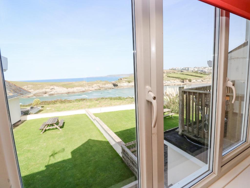 a room with a window with a view of the ocean at The Beach House in Newquay