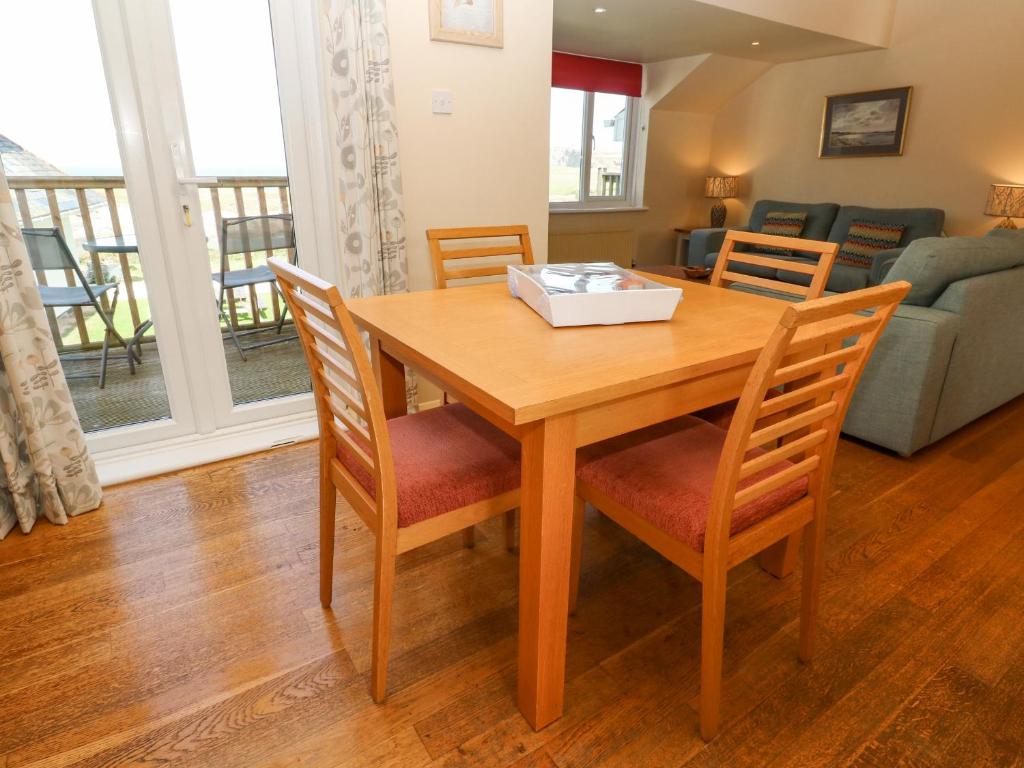 a wooden dining room table with chairs and a living room at The Beach House in Newquay