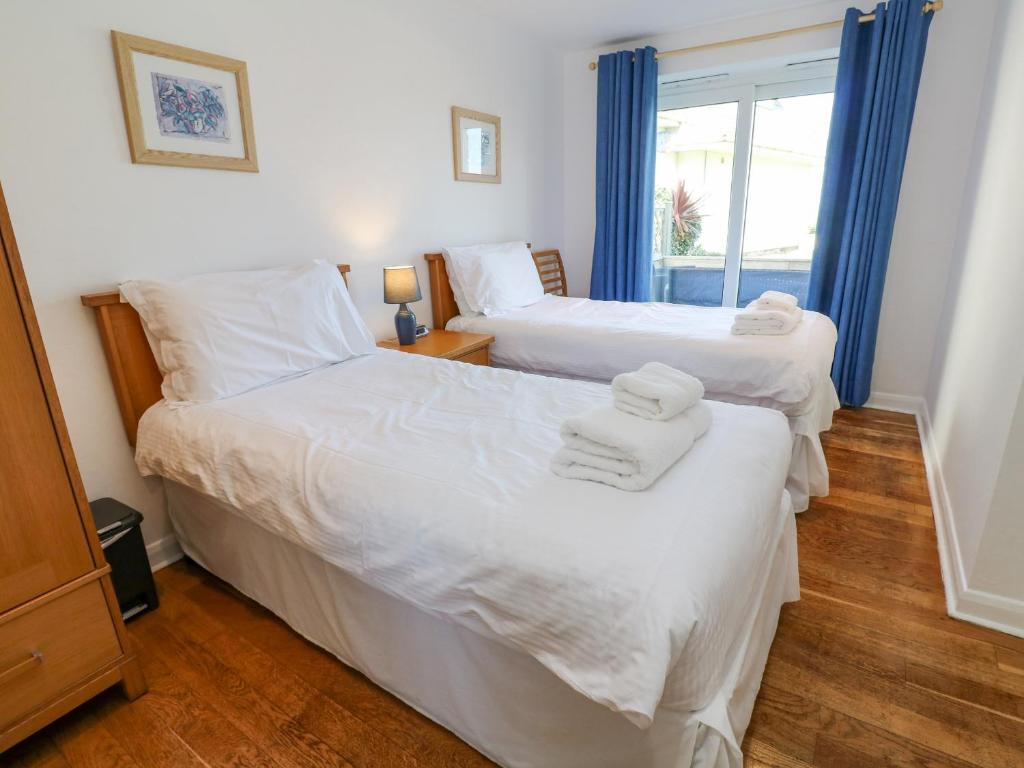 two beds in a room with a window at The Beach House in Newquay