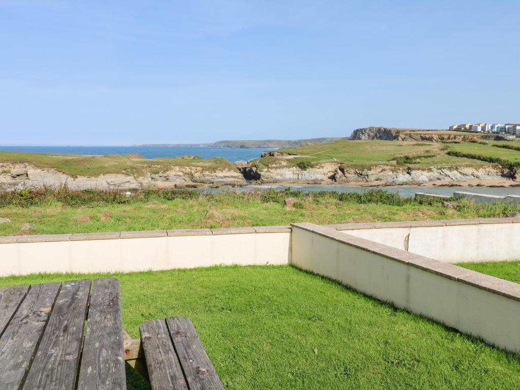 a wooden bench sitting on top of a field of grass at The Beach House in Newquay