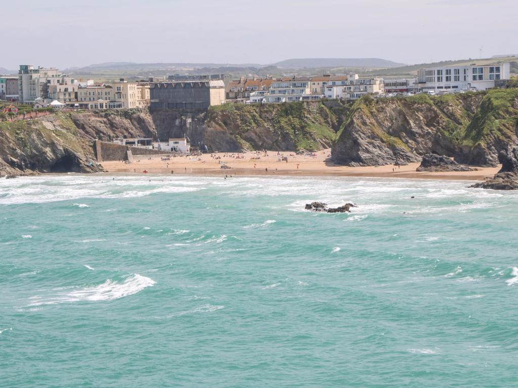 a beach with a group of people in the water at The Beach House in Newquay