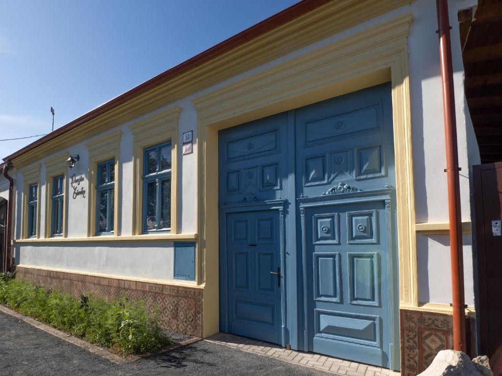 a garage with a blue door on a building at Penzión Záruby in Smolenice