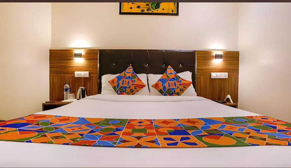 um quarto com uma cama grande e uma colcha colorida em Hotel Deluxe Residency em Mumbai