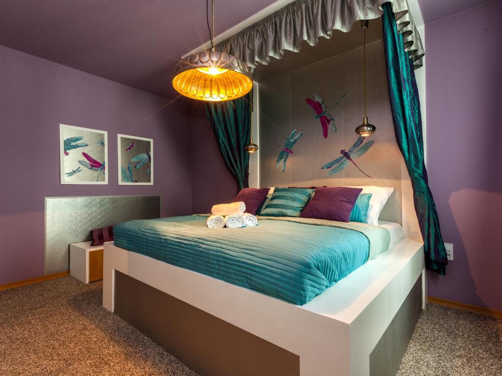 sypialnia z łóżkiem z fioletowymi ścianami w obiekcie Lovely Prague Apartments - Truhlářská w Pradze