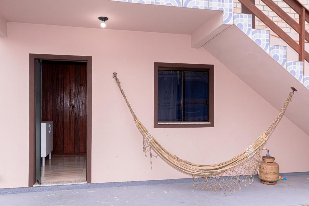 a hammock hanging on the side of a house at Casas do Seu Ari in Guarda do Embaú