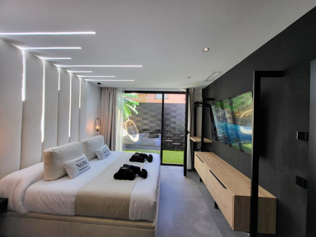1 dormitorio con 1 cama grande y TV en suites home ruidera en Ruidera
