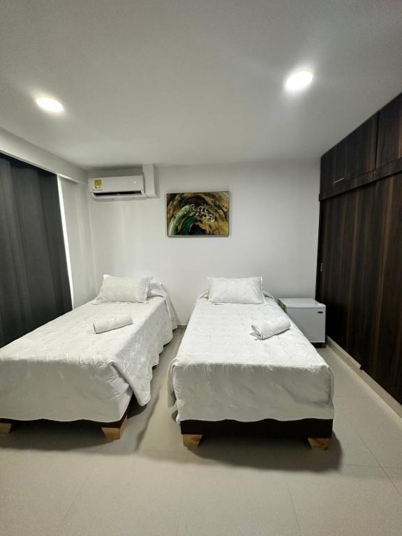 a bedroom with two beds and a painting on the wall at AMBAR CASA BOUTIQUE in San Andrés