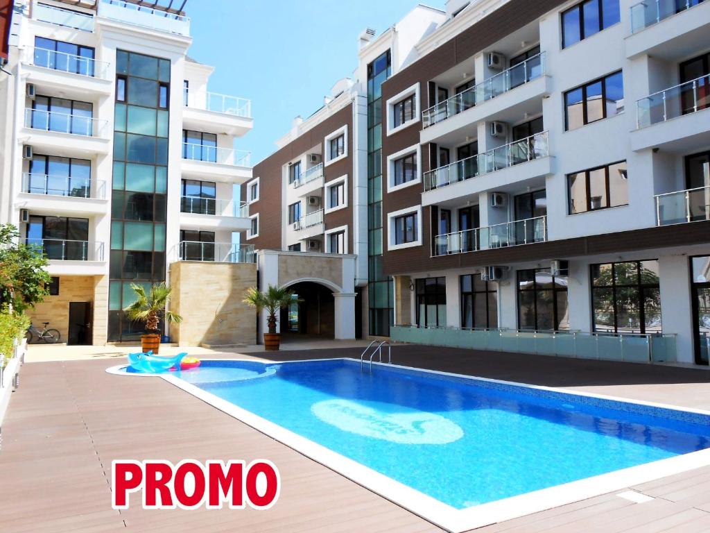 an apartment with a swimming pool in front of a building at Apartments Stamopolu Lux with pool view in Primorsko