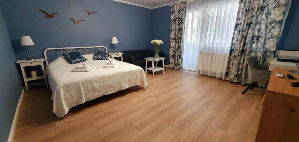 a bedroom with a bed with blue walls and wooden floors at D&C Studio II/Self-Check-In in Bucharest