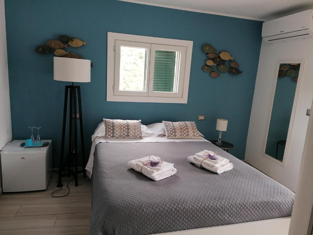 een slaapkamer met een bed met twee handdoeken erop bij La casa di Trilly in Sanremo
