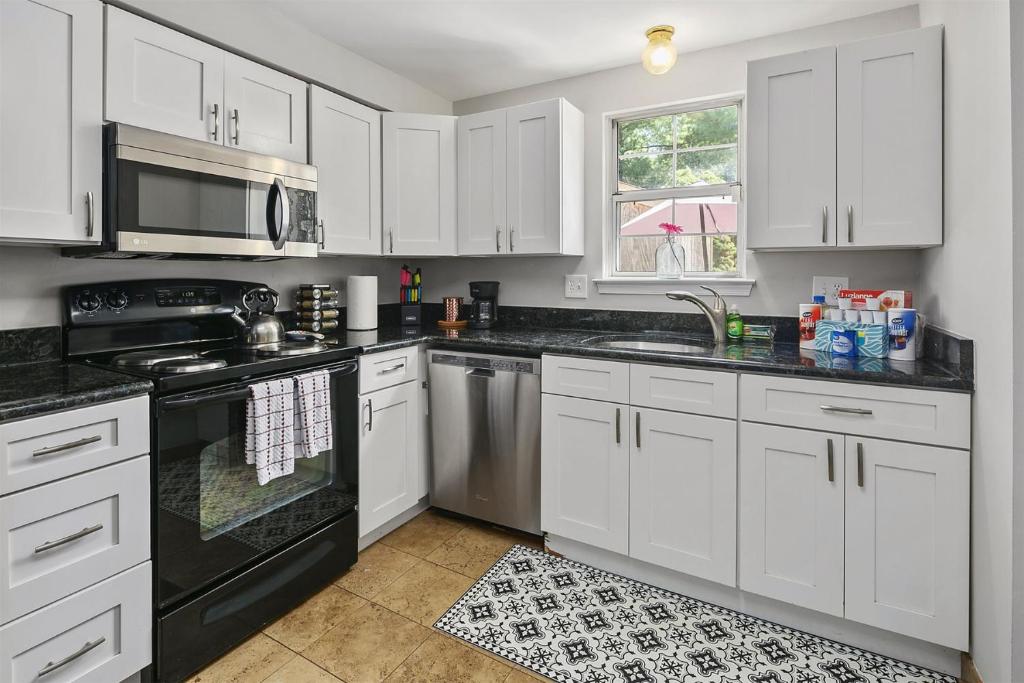 a kitchen with white cabinets and black appliances at TH in No VA, 40 Mins to DC, Pets OK, Fast WiFi in Sterling
