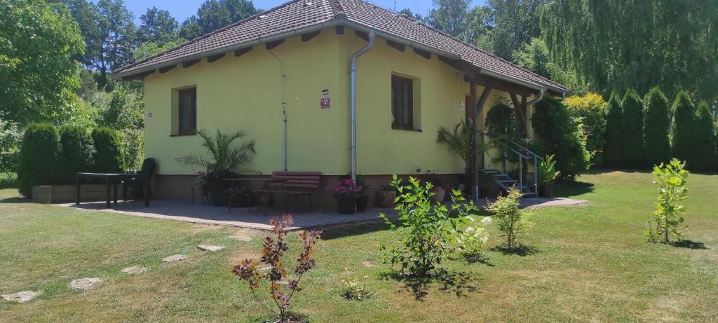 una pequeña casa amarilla con una mesa de picnic en un patio en Ubytování Švrčinová en Hluboká nad Vltavou