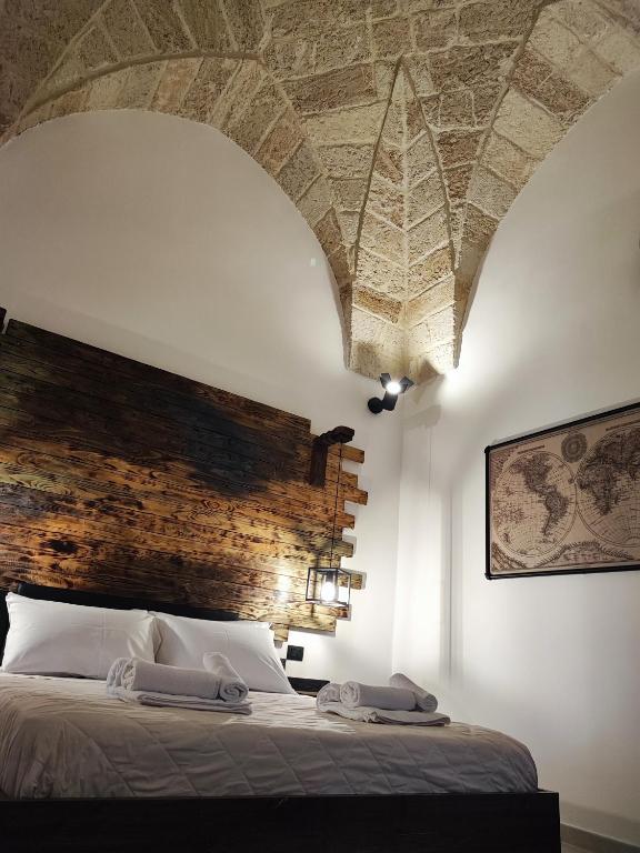 a bedroom with a large bed with a brick wall at Loft Porta Sud Civ.33 in Brindisi