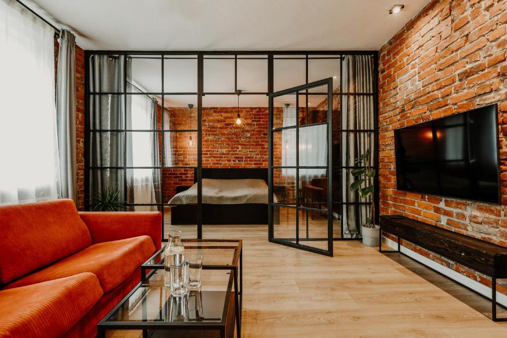 a living room with a couch and a brick wall at Old brick boutique apartments in Klaipėda