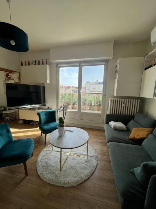 un salon avec un canapé et une table dans l'établissement Appartement cosy orangerie, à Strasbourg