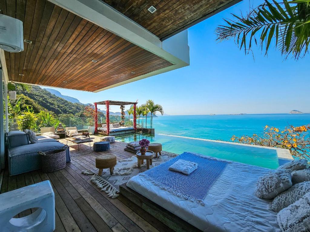 um quarto com uma cama e vista para o oceano em Linda casa no Joá, com vista incrível do mar do Rio no Rio de Janeiro