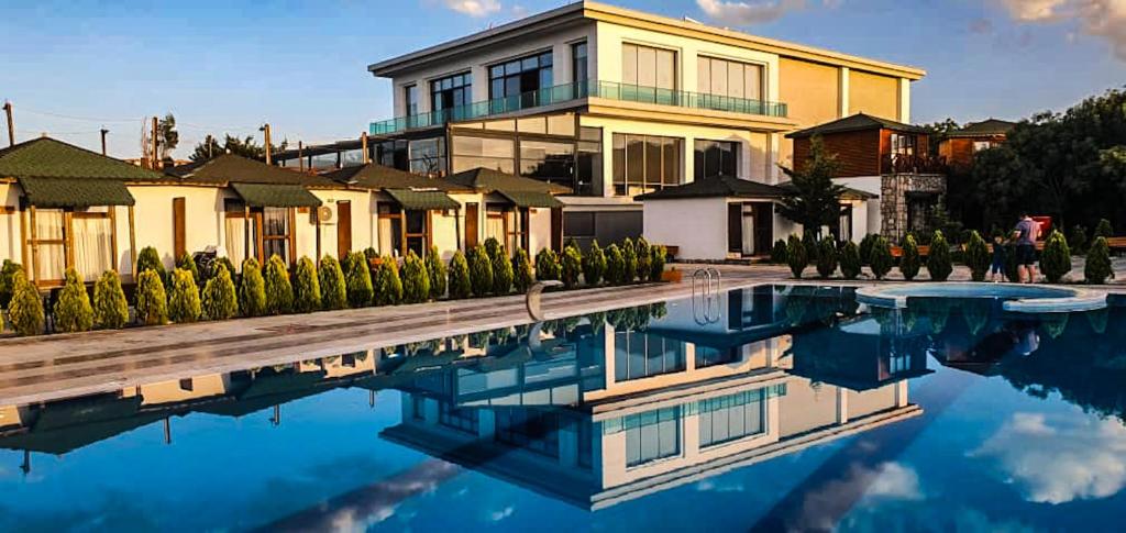 une maison avec piscine devant un immeuble dans l'établissement Dedeman Van Resort & Aquapark, à Van