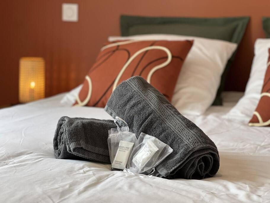 une paire de serviettes assises au-dessus d'un lit dans l'établissement * Domaine de la Solaie * - Proche Bords de Loire, à Saint-Denis-de-l'Hôtel