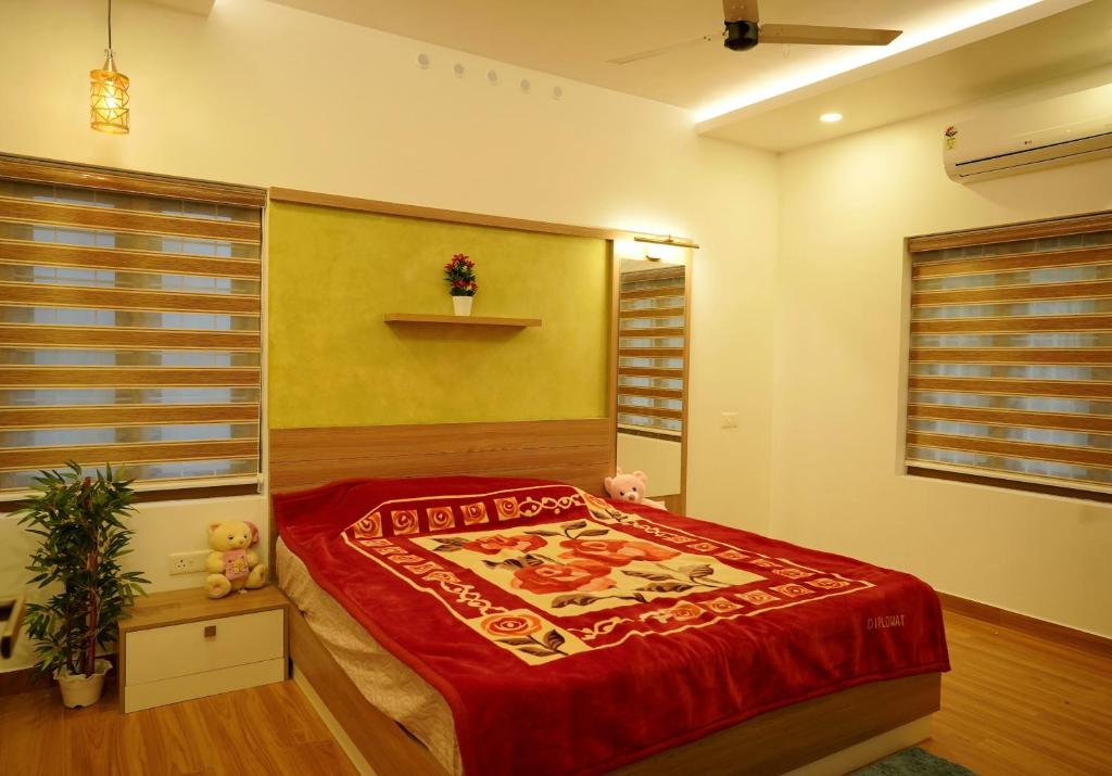 a bedroom with a bed with a red comforter at Luxury Homes - Cochin Airport - Nedumbassery in Angamaly
