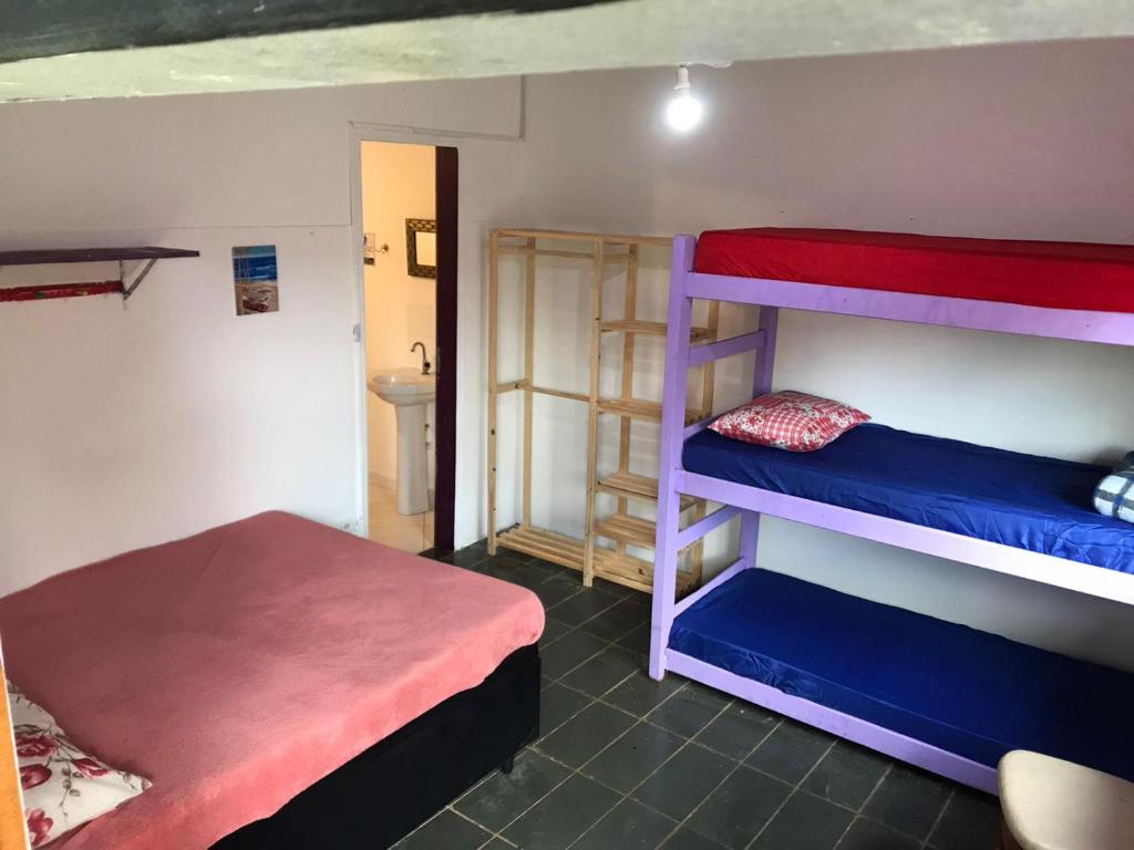 Pokój z 2 łóżkami piętrowymi i łóżkiem w obiekcie Farah Suítes e Passeio de barco w mieście Boiçucanga