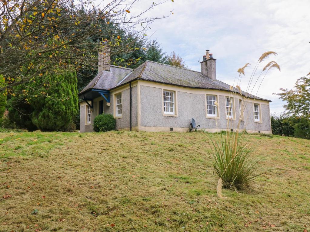 uma casa velha no topo de uma colina em North Lodge em Forfar