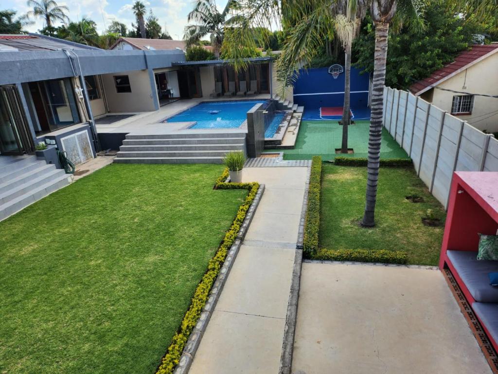 a backyard with a pool and a palm tree at 17 On Buffalo in Johannesburg