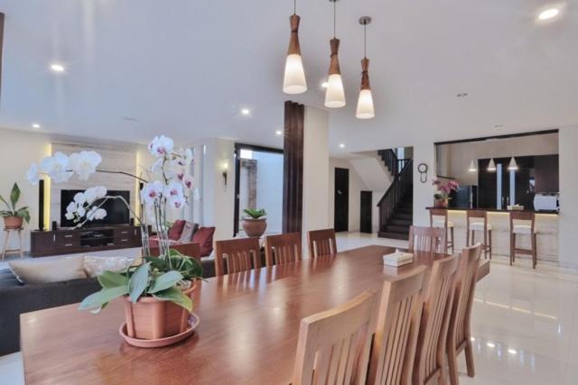 a dining room with a large wooden table and chairs at The Arnaya in Kuta