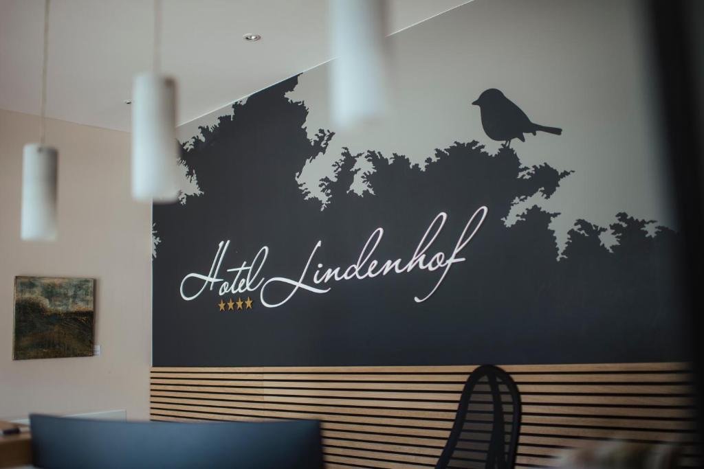 ein Schild an der Wand mit einer Bank in einem Zimmer in der Unterkunft Hotel Lindenhof in Erkelenz