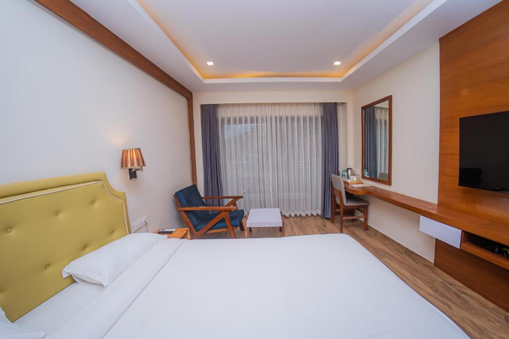 ポカラにあるHotel Fewa Tripのベッドとテレビが備わるホテルルームです。