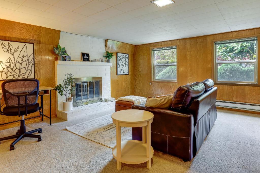een woonkamer met een leren bank en een open haard bij Charming and Cozy Seattle Apartment with Fireplace! in Seattle