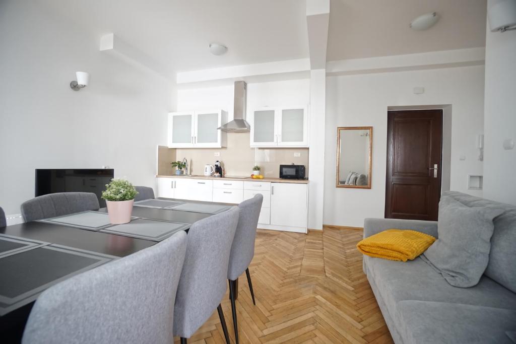 een keuken en een woonkamer met een tafel en stoelen bij Warsaw Premium Apartments Standard Old Town in Warschau