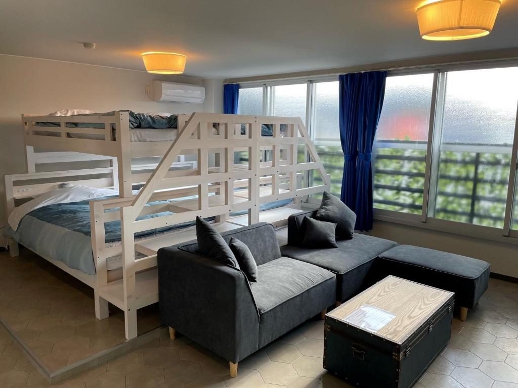 InnCocoSumu？ - Vacation STAY 04627v في كيريشيما: غرفة معيشة مع سرير بطابقين وأريكة