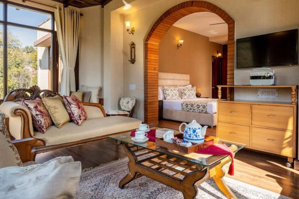 uma sala de estar com um sofá e uma mesa em Sanjwat Homestays Bhimtal - Largest 5BR Luxury Orchard Villa em Bhimtal