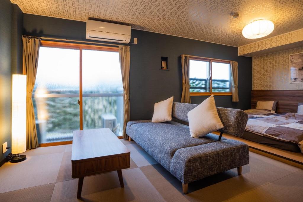 a living room with a couch and a bed at InnCocoSumu？ - Vacation STAY 09335v in Kirishima