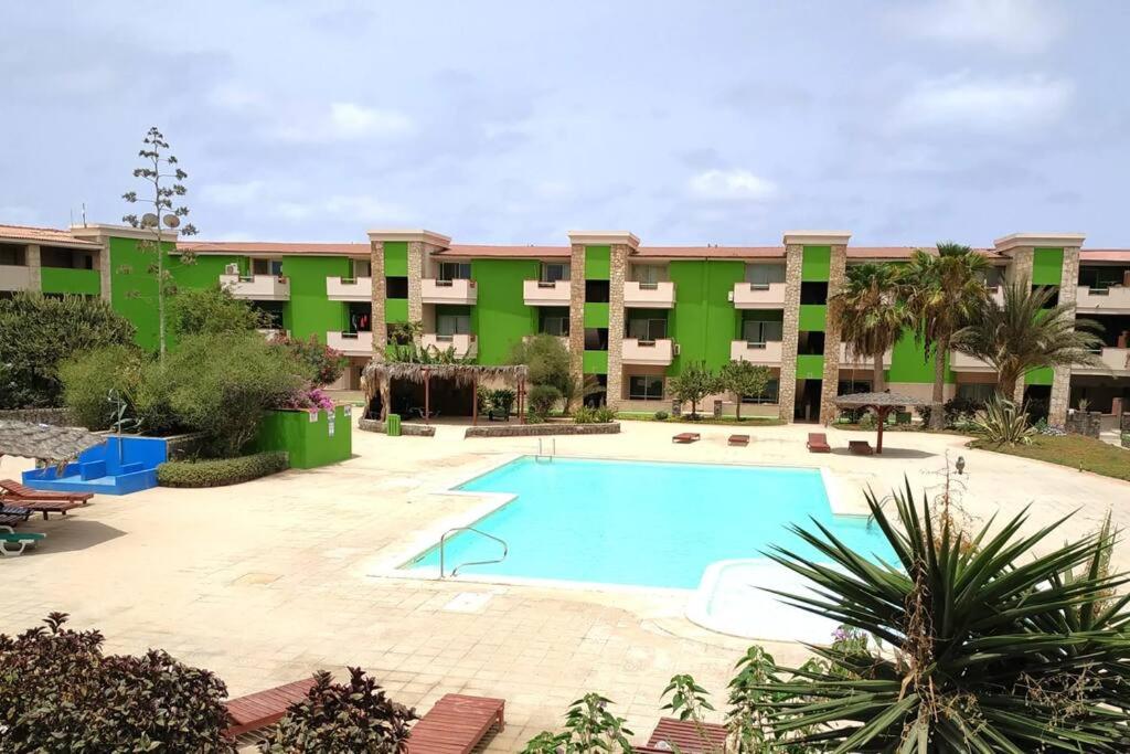 an apartment complex with a swimming pool in front of a building at Cozy Apartment with Pool, near Beach and Center in Santa Maria