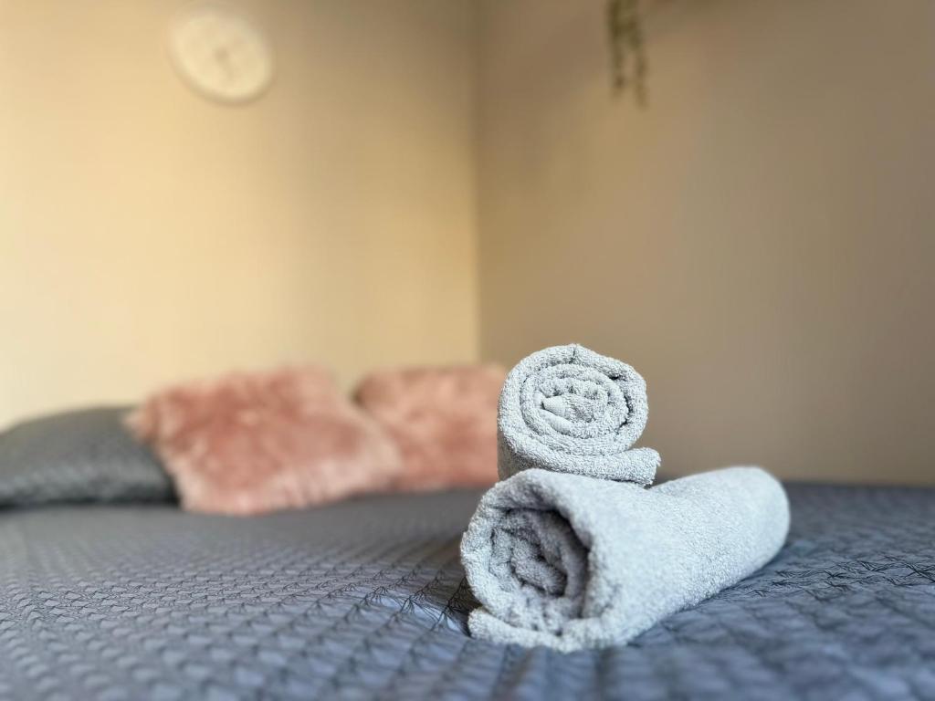 a pile of towels sitting on top of a bed at MMRent Desert Room in Gdańsk