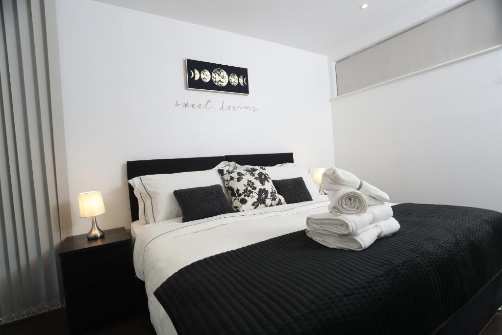 a bedroom with a bed with towels on it at Luxury Apartments in Central Watford in Watford