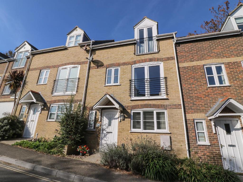 Casa de ladrillo con puertas y ventanas blancas en Castle Cove View, en Weymouth