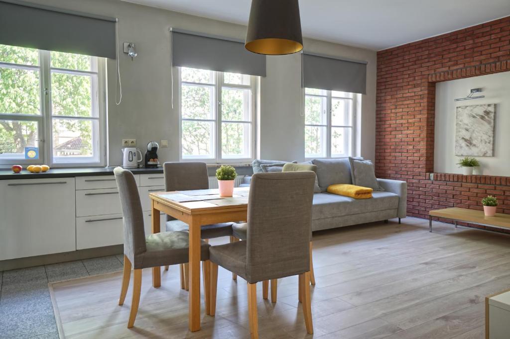 uma cozinha e sala de estar com uma mesa de madeira e cadeiras em Warsaw Premium Apartments Old Town Rycerska em Varsóvia