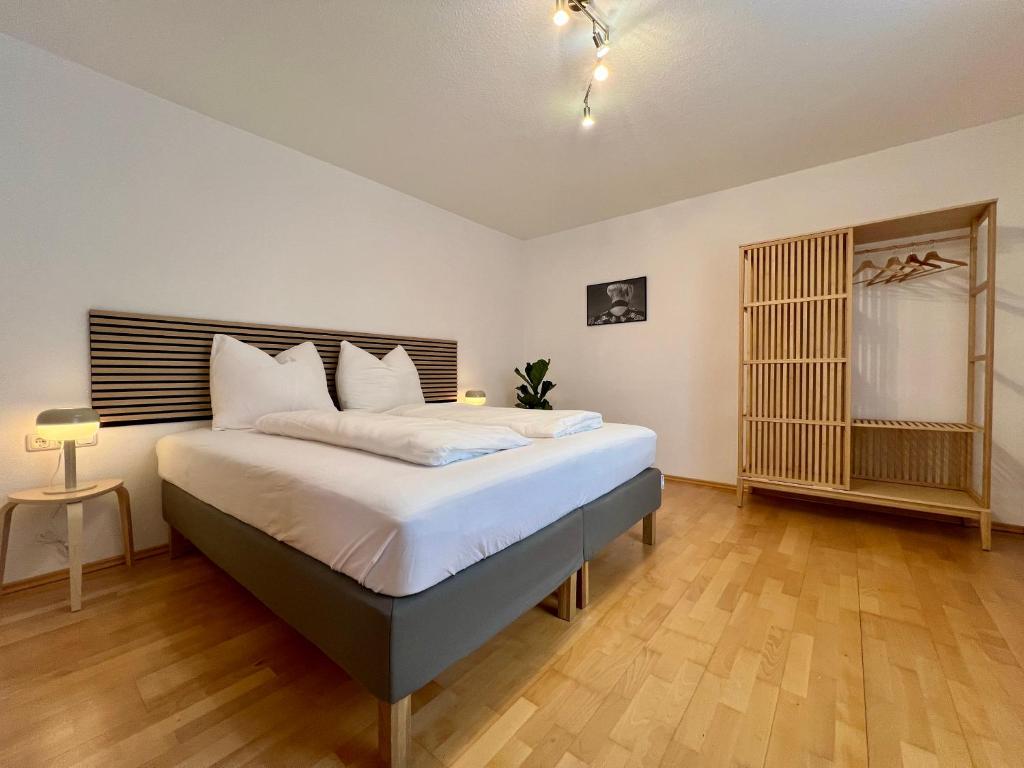 um quarto com uma cama grande e lençóis brancos em Stadthaus 1911 em Bludenz