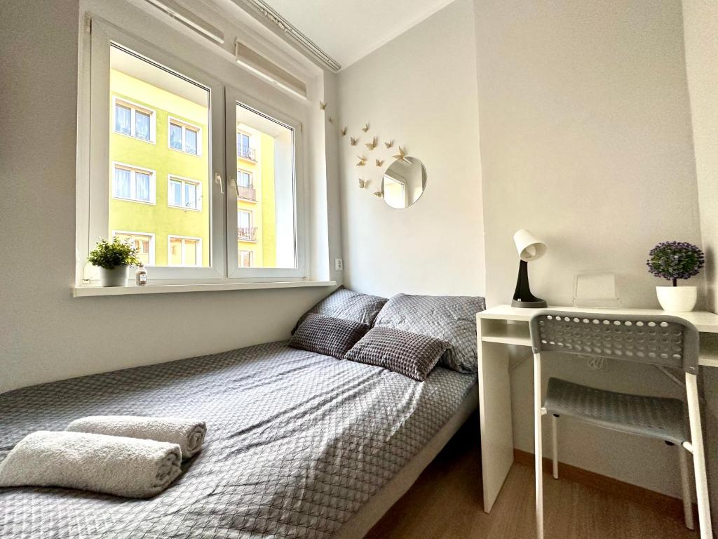 a small bedroom with a bed and a window at MMRent Spring Room in Gdańsk