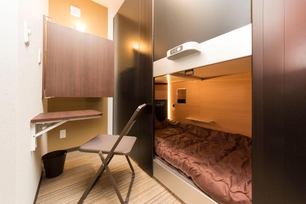 東京にあるRyoma Ikebukuro female only Guest House Vacation STAY 16032vのベッドと椅子付きの小さな部屋です。