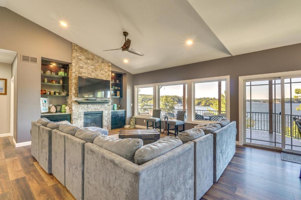 a living room with a large couch and a fireplace at Spacious Lake of the Ozarks Escape with Deck and Views in Linn Creek