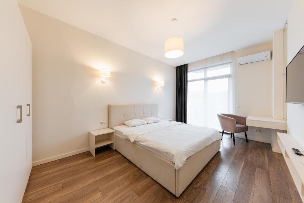 um quarto branco com uma cama e uma secretária em Luxury Apartments “Dream City” em Uzhhorod