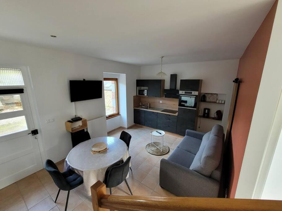 sala de estar con sofá y mesa en Logement 2 à 4 pers - moulin en Saint-Carreuc