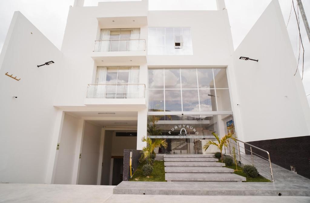 a white building with stairs in front of it at Suite Spa Puñuykuna in Cajamarca