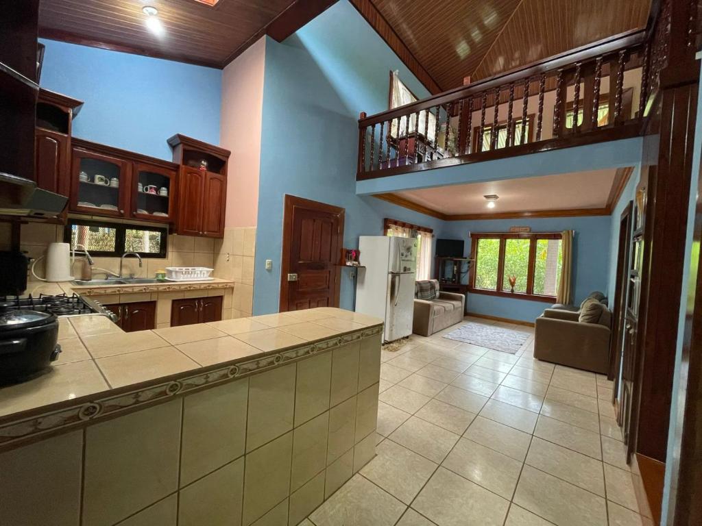 a large kitchen with a counter top and a living room at Complejo Ecoturistico Tamandua in Drake