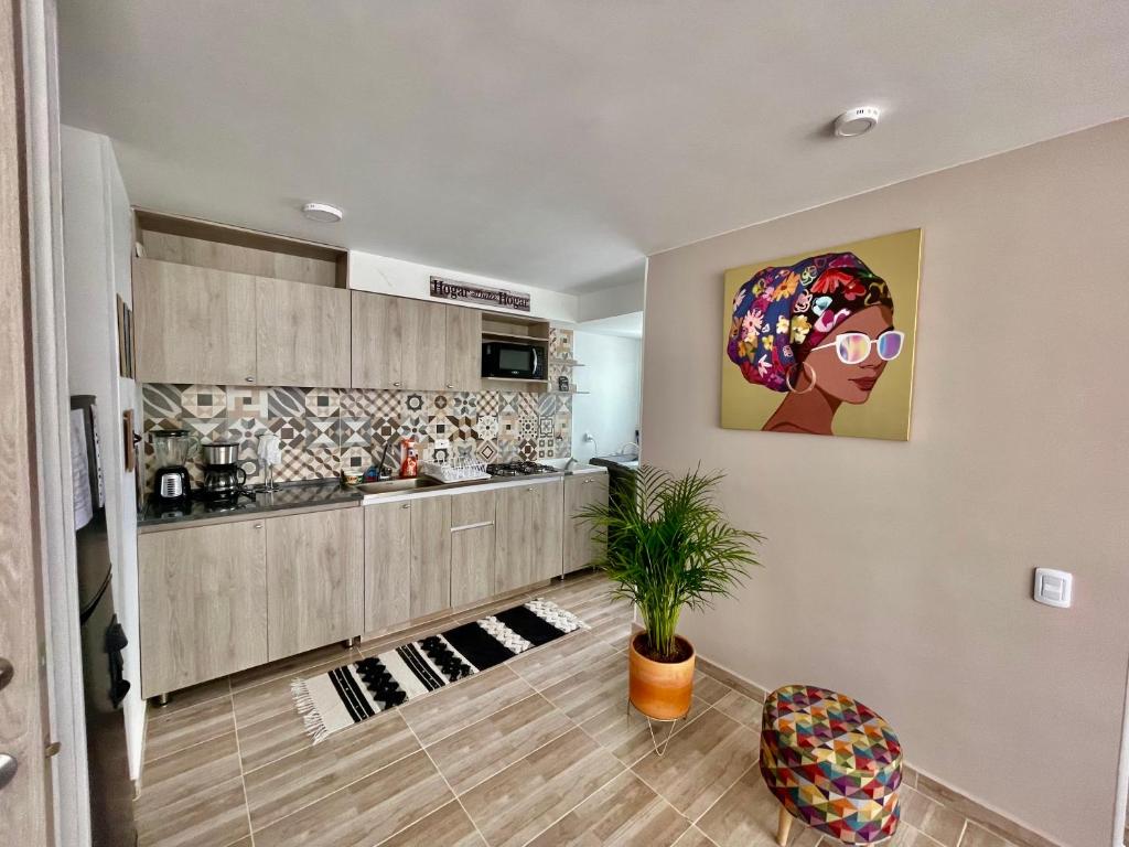 una cocina con armarios de madera y una pintura en la pared en Hermoso apartamento para estrenar, en Barranquilla