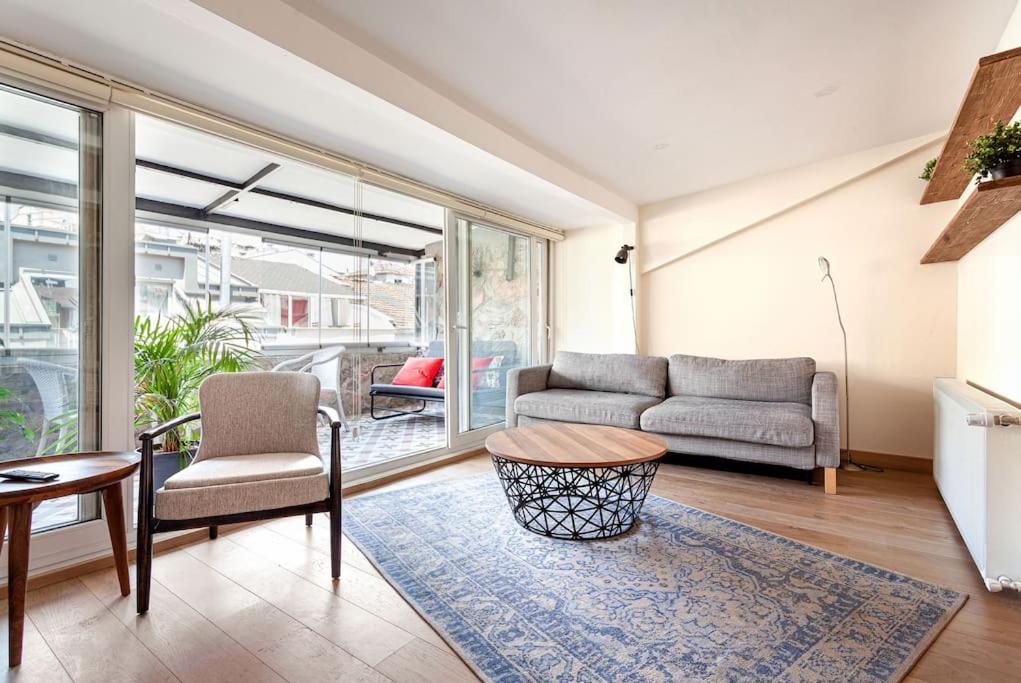uma sala de estar com um sofá e uma mesa em Prime location with terrace em Istambul