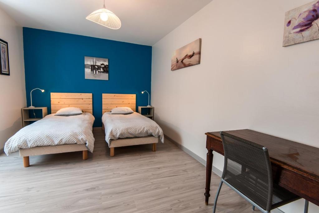 1 dormitorio con 2 camas y piano en Le cèdre du Prieuré, en Montreuil-le-Henri